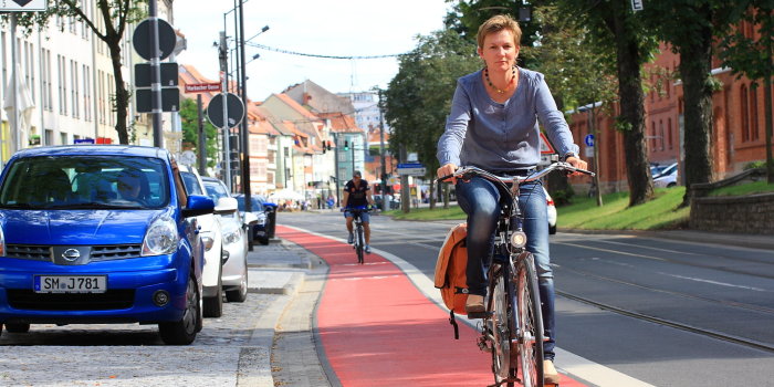 Radfahrerin befährt einen rot markierte Fahrspur, die Fahrrädern vorbehalten ist.