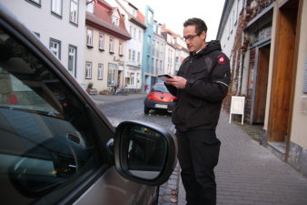 Ein Mitarbeiter schreibt einen Strafzettel für ein falsch abgestelltes Fahrzeug in der Erfurter Innenstadt.