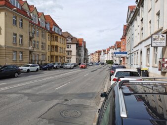 mehrspurige Straße mit parkenden Autos