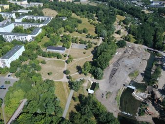 Grün- und Waldflächen mit Wegen neben Plattenbaugebiet