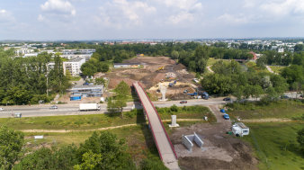 eine Brücke führt über eine Straße und verbindet eine Parklandschaft, in der gebaut wird