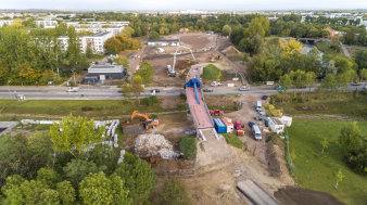 eine Großbaustelle mit einem Brückenneubau und einer im Bau befindlichen Parklandschaft