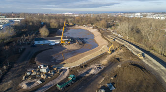 Luftaufnahme einer Baustelle mit Teich in einer Parklandschaft