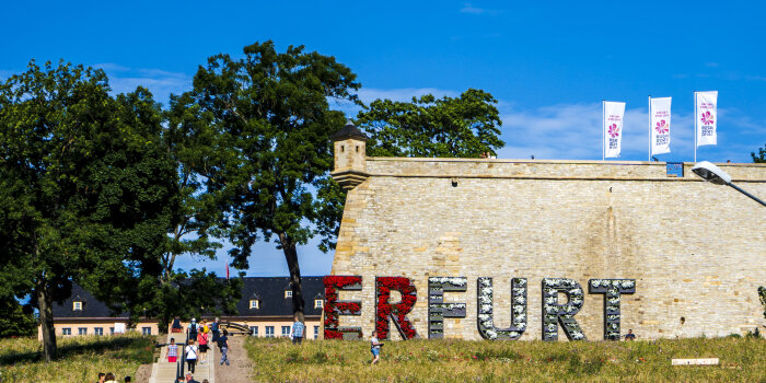 der Hang des Erfurter Petersberghangs mit einem großen Erfurt-Schriftzug vor einer Festungsmauer