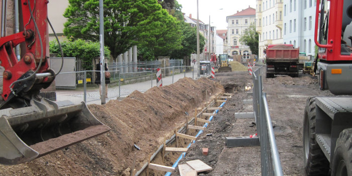 offene Straße mit Kanalbau und Baufahrzeugen