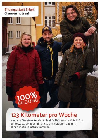 Vier Streetworker stehen im Winter an einer Mauer in der Stadt. Darunter steht der Satz: "123 Kilometer pro Woche sind die Streetworker der Aidshilfe Thüringen e. V. in Erfurt unterwegs, um Jugendliche zu unterstützen und mit ihnen ins Gespräch zu kommen."