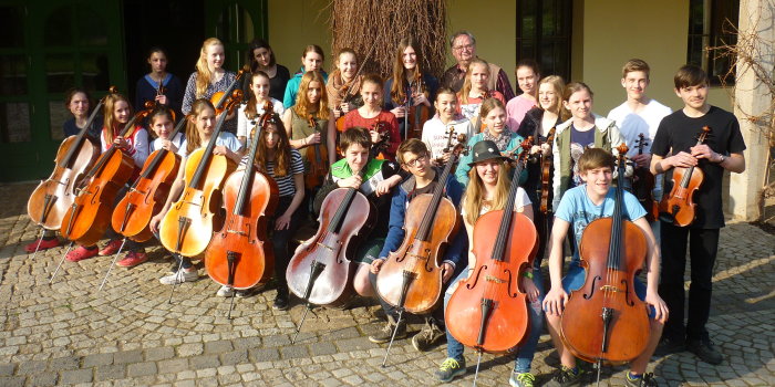 Die Mädchen und Jungen des Kinderstreichorchesters mit ihren Instrumenten und Orchesterleiter Jens Nedeß im Hof des Rittergutes Lützensömmern bei ihrer Orchesterfreizeit im April 2016