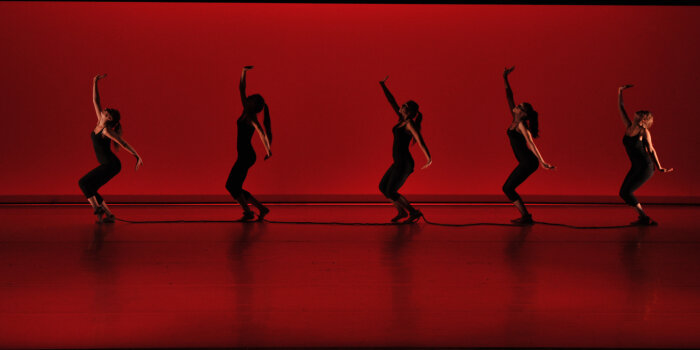 Foto: Tanztheaterstück "Change" auf der Bühne der Erfurter Oper. © Alice End Tänzerinnen auf rot erleuchteter Bühne.