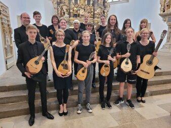 Kinder und erwachsene Schüler mit ihren Instrumenten vor dem Altar der Kaufmannskirche