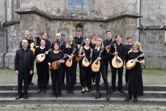 Instrumentalisten mit Mandolinen und Gitarren vor einer Kirche