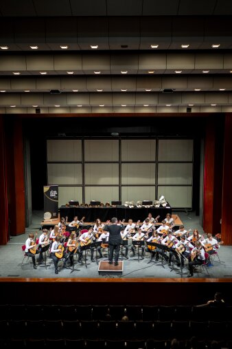 ein Gitarrenorchester mit rund 25 Mitspielenden auf einer Bühne