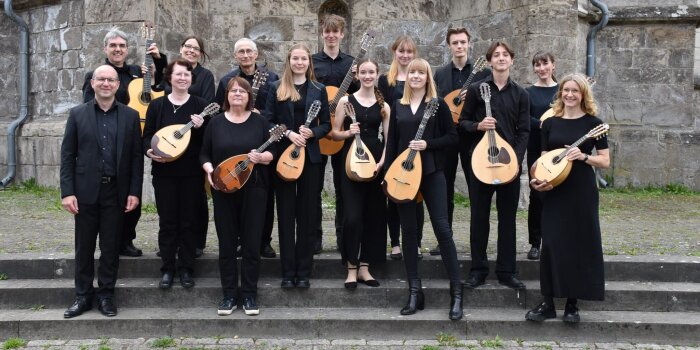 Instrumentalisten mit Mandolinen und Gitarren vor einer Kirche