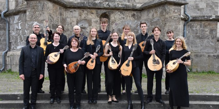 Instrumentalisten mit Mandolinen und Gitarren vor einer Kirche