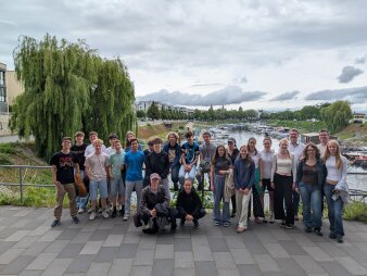 Schülergruppe vor Flusslandschaft