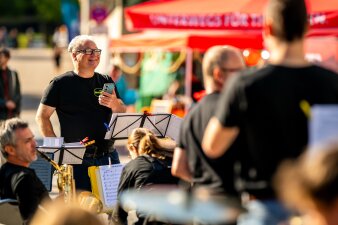 Ochesterleiter vor dem Auftritt lachend vor dem Ensemble