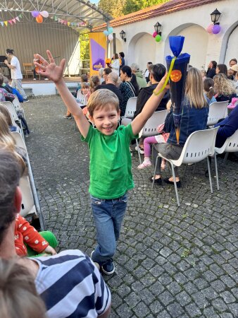 Junger Musikschüler hält stolz die Zuckertüte in die Höhe