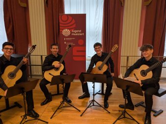 Schüler mit Gitarre auf Bühne