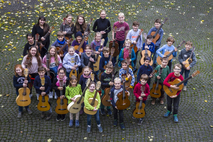 Das Kinderzupforchester mit seiner Leiterin Karoline Laier Kinder mit Zupfinstrumenten im Hof der Musikschule