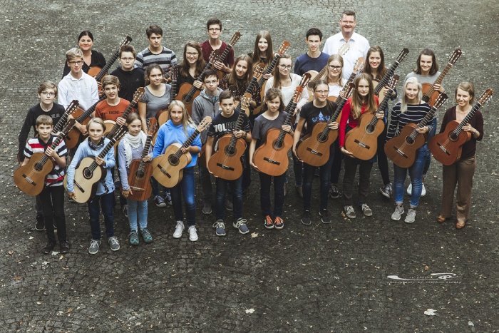 Das Jugendgitarrenensemble im November 2017 Die Dozenten und Musiker des Jugendgitarrenensemble mit ihren Instrumenten im Hof der Musikschule