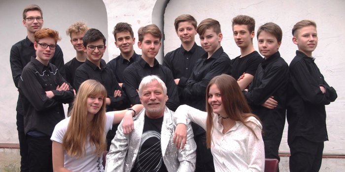 Der Orchesterleiter Frank Beierlein mit den jungen Musikern der "Heißen Drähte" im Hof der Musikschule