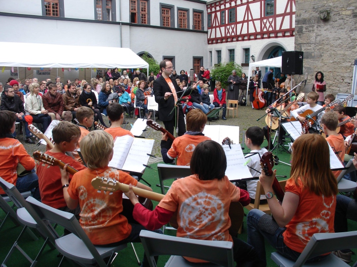 Das Kinderzupforchester spielt vor mehreren hundert Gästen im Schulhof