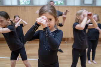 tanzende Kinder formen mit den Händen ein Fernrohr