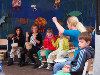 Kinder mit Djemben (Trommeln) auf der Bühne im Hof der Musikschule