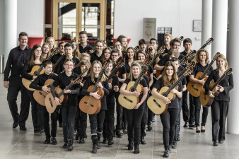 Die Kinder des Jugendgitarrenensembles mit ihren Instrumenten im Foyer des Opernhauses