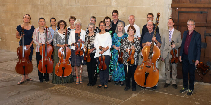 ein Gruppenfoto mit 18 Personen und verschiedenen Streichinstrumenten