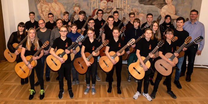 Kinder mit Gitarren im Saal der Musikschule.