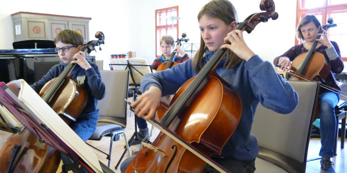 Kinder mit Violoncelli beim Musizieren