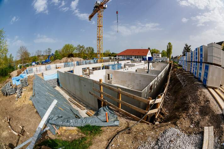 Das Foto zeigt Rohbauwände und einen Kran auf der Baustelle der Grundschule 19.