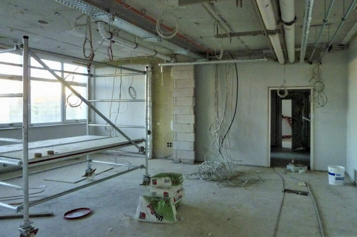 Das Foto zeigt deinen Klassenraum während der Sanierungsarbeiten und Kabel hängen aus der Decke.