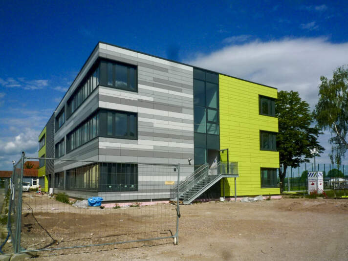 Das Foto zeigt die fertiggesellte Fassade in grau und grün der Gemeinschaftsschule Kerspleben.