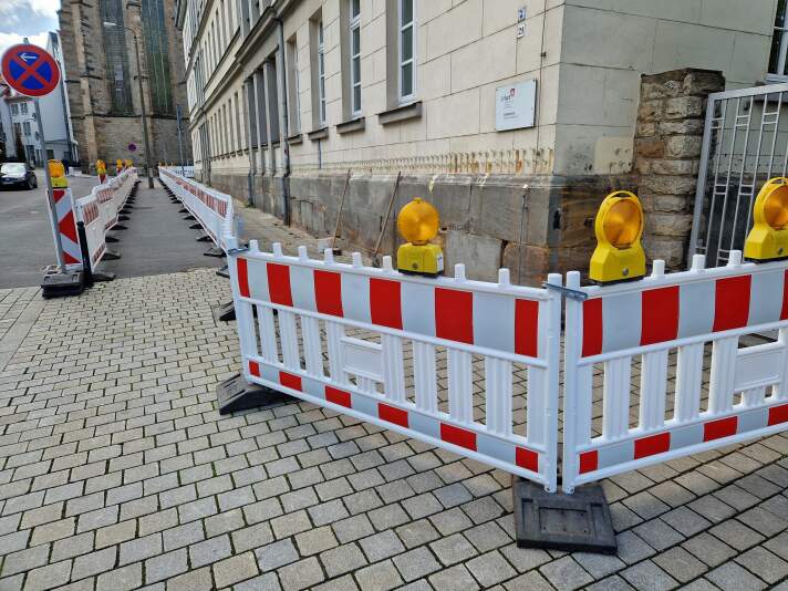 Das Foto zeigt, wie der Sockel der Barfüßerschule abgedichtet wird sowie die Baustellenabsicherung.