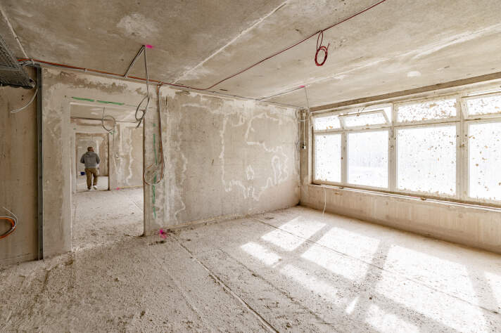 Das Kitagebäude von innen nach der Entkernung mit Blick durch den Gang in verschiedene Räume.