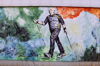 Das Foto zeigt einen Wanderer, der auf die Außenseite der Sporthalle gemalt wurde.