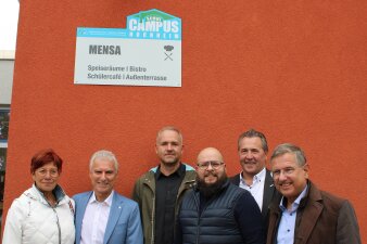 Das Foto zeigt sechs Personen vor dem Schild der Mensa der Gemeinschaftsschule Hochheim.