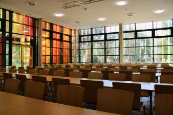Das Foto zeigt die neue Mensa der Riethschule mit Tischen und Stühlen.