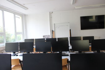 Das Foto zeigt einen möblierten Klassenraum mit vielen Computern.