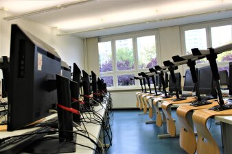 Das Foto zeigt ein möbliertes Klassenzimmer mit PC-Arbeitsplätzen.
