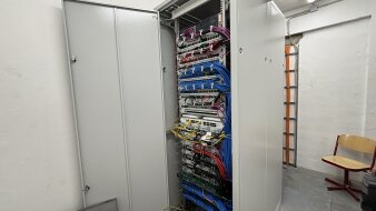 Das Foto zeigt einen Verteilerschrank mit vielen darin enthaltenen Kabeln.