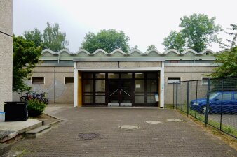 Das Foto zeigt den Eingangsbereich der Sporthalle von außen vor der Sanierung.