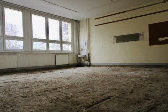 Das Foto zeigt einen entkernten Unterrichtsraum mit gelben Wänden.
