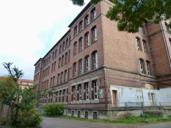 Das Foto zeigt das Schulgebäude mit Klinkerfassade in der Außenansicht vor der Sanierung.