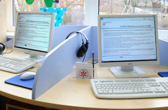 Zwei getrennte PC-Arbeitsplätze mit Kopfhörer, Tastatur und Maus.