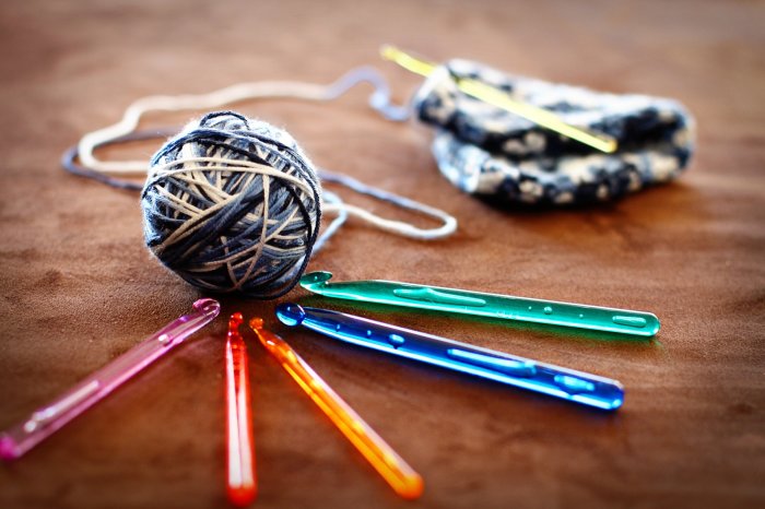 Hobby-Markt – Wer hilft beim Wiederentdecken interessanter Beschäftigungen wie Stricken, Häkeln, Basteln, Modellieren, Sammeln und mehr? Farbige Häkelnadeln um ein Wollknäuel.