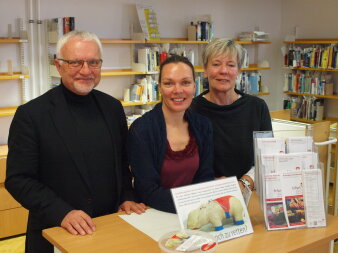 Drei Mitglieder des Freundeskreises der Stadt- und Regionalbibliothek Erfurt stehen hinter einer Theke.