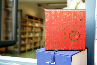 Foto einer roten Box mit Tee vor einem Bücherregal in der Stadt- und Regionalbibliothek