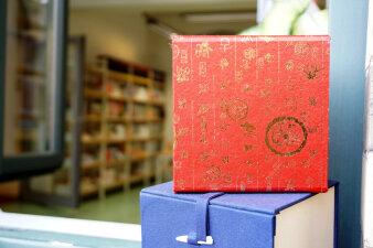 Foto einer roten Box mit Tee vor einem Bücherregal in der Stadt- und Regionalbibliothek